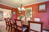 rectangular brown wooden dining table with chairs set beside wall