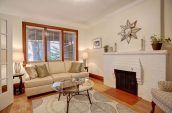 oval glass coffee table in living room with sofas and fireplace