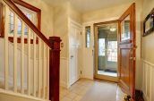 brown wooden door open in house foyer