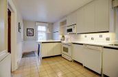 kitchen with white cabinets and appliances with tiled floors