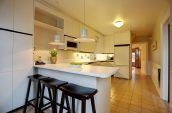three brown stools in front of white kitchen counter