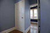 view of white 6-panel door with blue painted walls