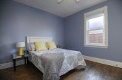 gray and white bed linen inside room with blue walls
