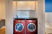 red front-load washer and dryer with white wooden doors