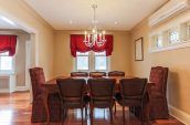 rectangular brown wooden dining table with chairs beside wall