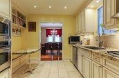 red curtain on window in the background past dining room from kitchen