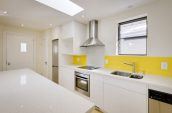 kitchen with white cabinets and yellow wall highlight