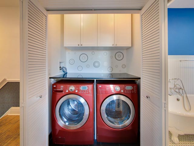 red front-load clothes washer and dryer set in closet
