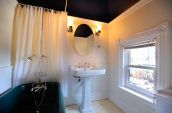 white pedestal basin in bathroom with green bathtub