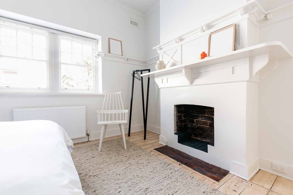 white fireplace beside white wooden chair