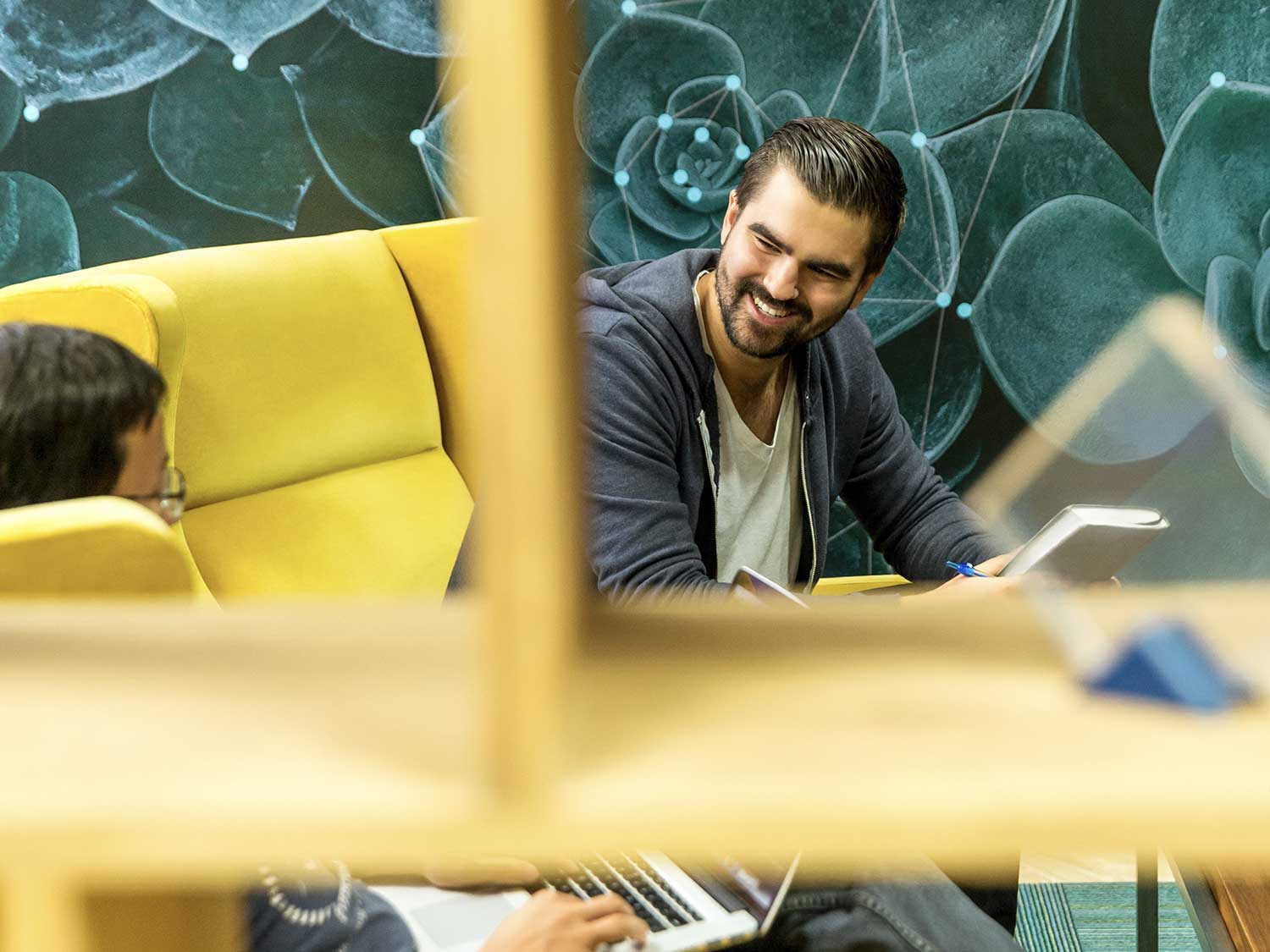 two people sitting on yellow sofa