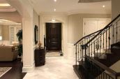 home foyer with black door staircase and tiled floors