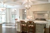 bright white kitchen with island and chandeliers