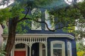 blue painted house surrounded by trees