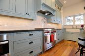 range hood above gas range in kitchen with blue cabinetry