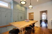 pendant lamps above dining set in kitchen with blue cabinetry