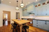 pendant lamps above dining set in kitchen with blue cabinetry