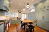 turned-on pendant lamps in kitchen with blue cabinetry