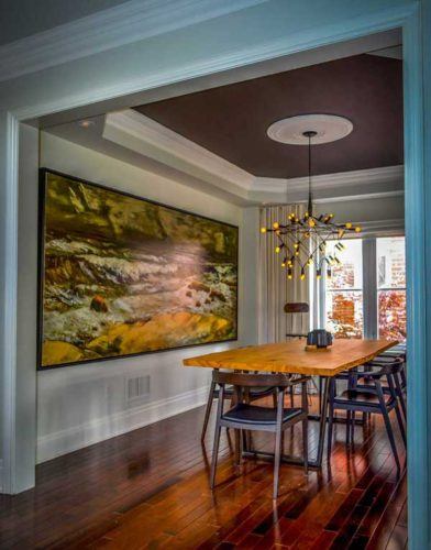 dining room with hardwood floors large painting on the wall wooden dining set and painted ceiling