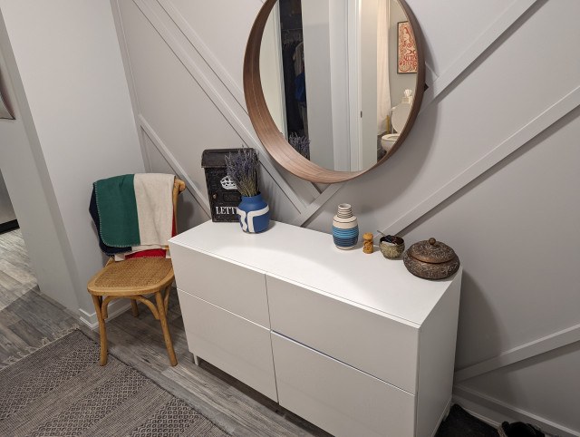 dresser and mirror against a feature wall